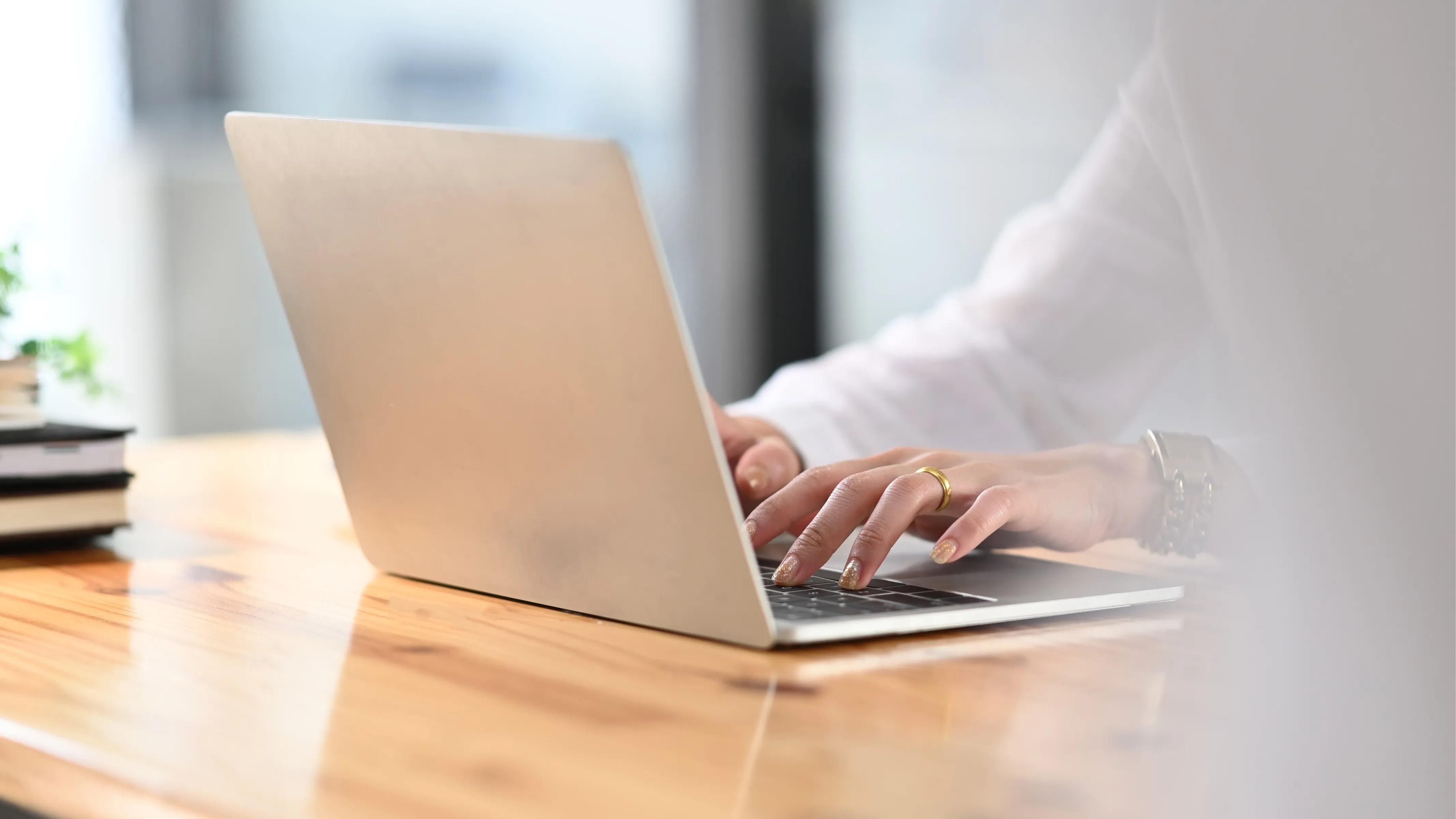 Hands typing on laptop